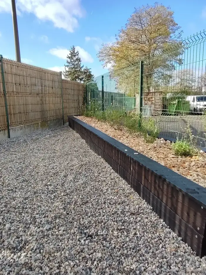 Longues bordures en bois brûlé le long d'une clôture