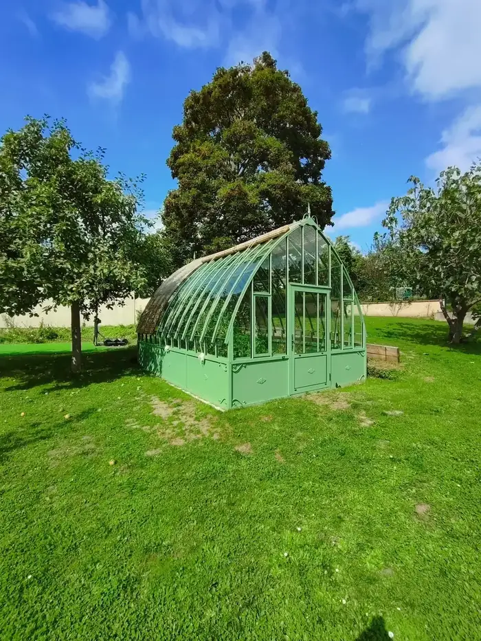 Serre de jardin installée sur une pelouse entretenue